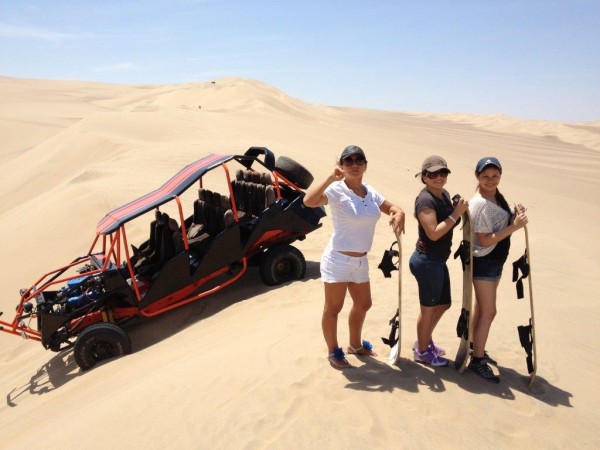 Sandboarding on the dunes of the desert of Huacachina en Ica Peru